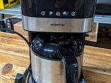 a coffee maker that is sitting on a wooden table