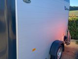 an image of a trailer parked in a gravel lot