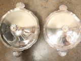two silver dishes sitting on a counter top