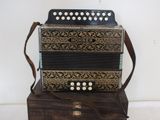 a black and gold accordion sitting on top of a wooden box