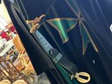 a coat with a green ribbon and a pair of scissors attached to it