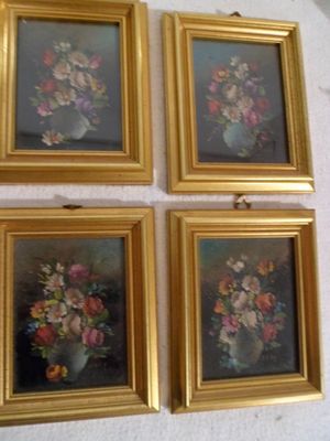 quatre tableaux encadrés représentant des fleurs dans un vase accrochés au mur