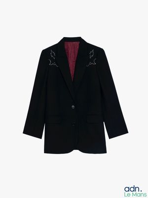 La veste est noire et a une doublure rouge.
