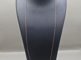 a gold chain necklace on a mannequin display