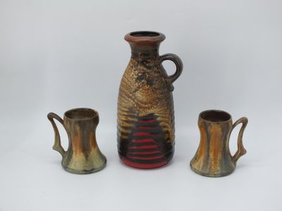 trois vases posés l'un à côté de l'autre sur une surface blanche