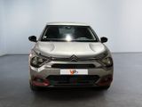 the front view of a silver car parked in a white room