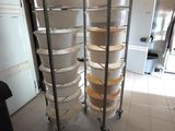 several trays of food are stacked on a metal rack in a kitchen