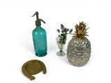 a pineapple, a glass bottle, and a horseshoe on a white background