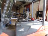 a fork lift truck in a garage with the door open