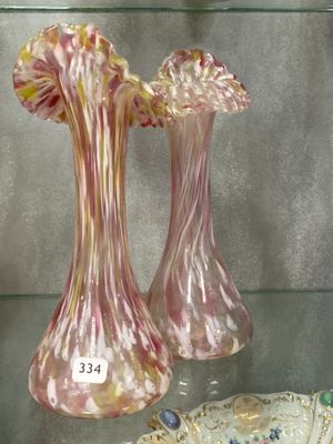 two glass vases on display in a glass case