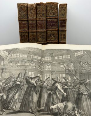 un vieux livre sur lequel figure le dessin d'un groupe de personnes dans une pièce