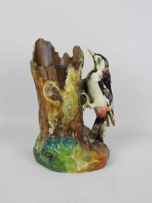 une figurine représentant un oiseau perché sur une souche d'arbre