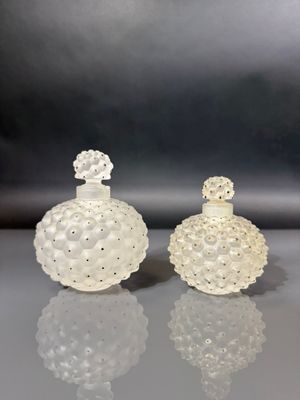 pair of white glass perfume bottles sitting on top of a table