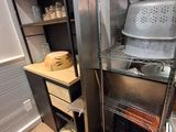 une cuisine équipée d'une cuisinière, d'étagères et d'un évier