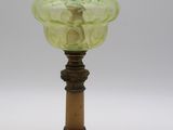 une photo d'une lampe en verre vert posée sur un socle en bois