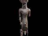 une statue en bronze représentant une femme tenant un poisson, posée sur un socle en bois