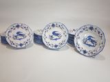 four blue and white plates with birds and flowers on them