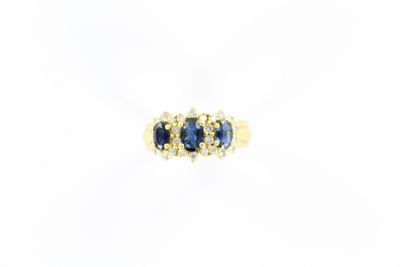 gros plan d'une bague en or avec saphirs bleus et diamants