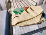 a bag sitting on top of a bed next to a pillow