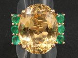 une image représentant une bague sertie d'une topaze jaune entourée d'émeraudes
