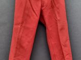 un pantalon rouge suspendu à un cintre accroché au mur