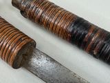 two different types of knives on a white surface