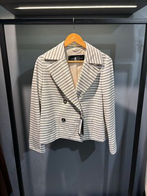 une veste à rayures blanches et noires suspendue à un cintre dans une armoire