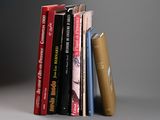 several books are stacked on top of each other on a gray surface