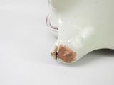 a close up of a white vase with a brown spot on it