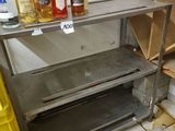 bottles of alcohol are lined up on a metal shelf in a kitchen