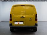 the back of a yellow van parked inside of a building