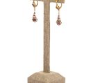a close up of a pair of earrings on a stand