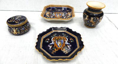 three pieces of pottery sitting on a white table
