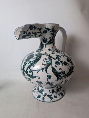 a white vase with a green and blue design on it