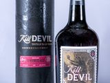bottle of red devil rum sitting next to a black box on a white surface
