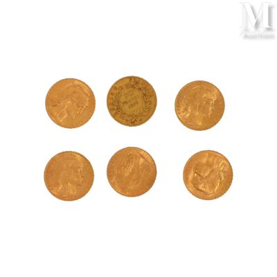 six pièces d'or sont disposées en ligne sur une surface blanche