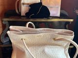 a white purse sitting on top of a stack of suitcases