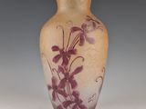 a vase with purple flowers on it sitting on a table