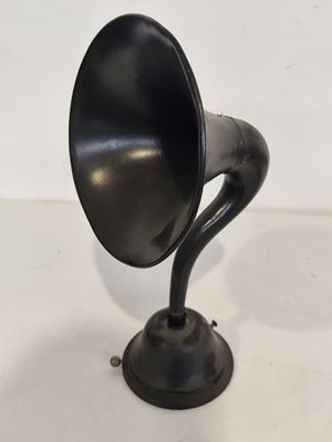 un vieux gramophone noir posé sur une surface blanche