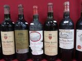 Plusieurs bouteilles de vin sont alignées sur une table rouge