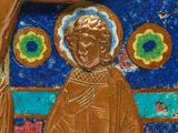 a gold statue of a man holding a cross