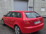 une voiture rouge garée devant un bâtiment