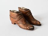 pair of antique brown leather shoes with gold accents on white background
