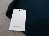 a picture of a black sweater with a white tag on it