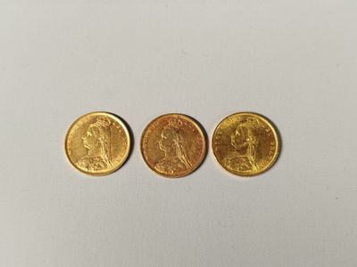 three different types of gold coins on a white surface