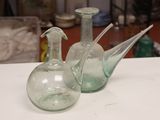 deux vases en verre vert posés sur une table blanche
