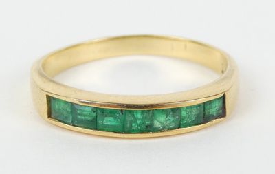 un gros plan d'une bague en or sertie d'émeraudes