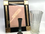 une photo représentant un cadre et un vase posés sur une table