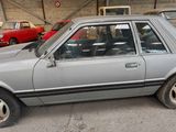 a silver car parked in a garage with other cars in the background