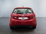 the back of a red car in a room with a white wall